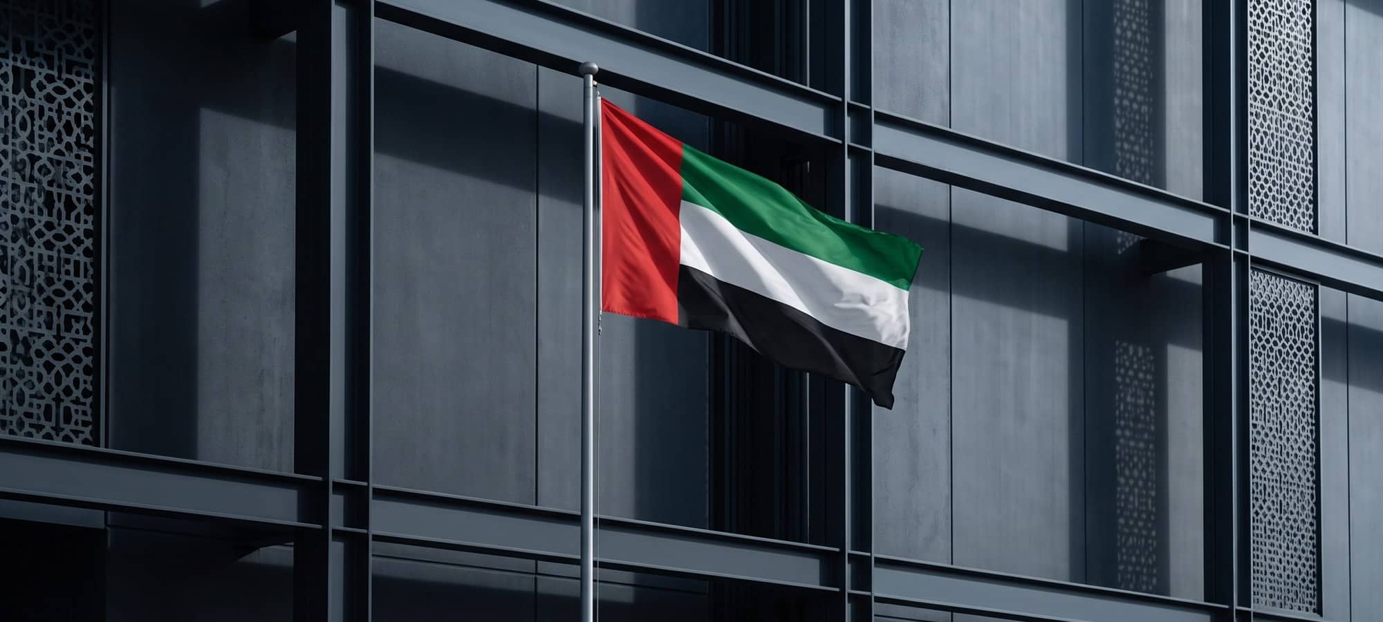 The flag of the United Arab Emirates flying beside an office building