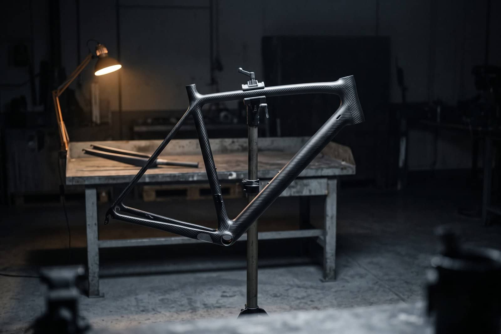 A carbon fibre bicycle frame on a workshop stand