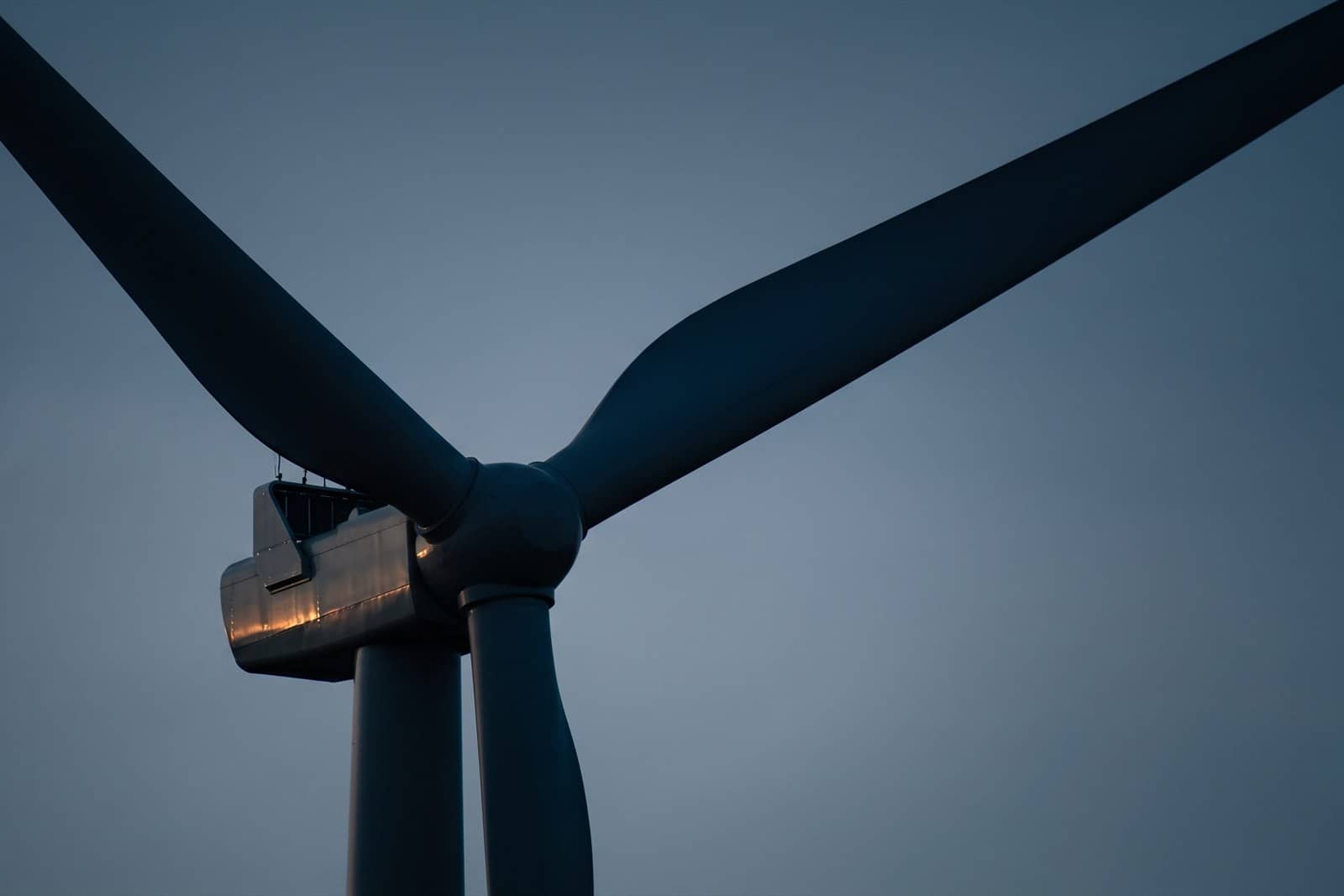 A wind turbine nacelle and blades against the sky