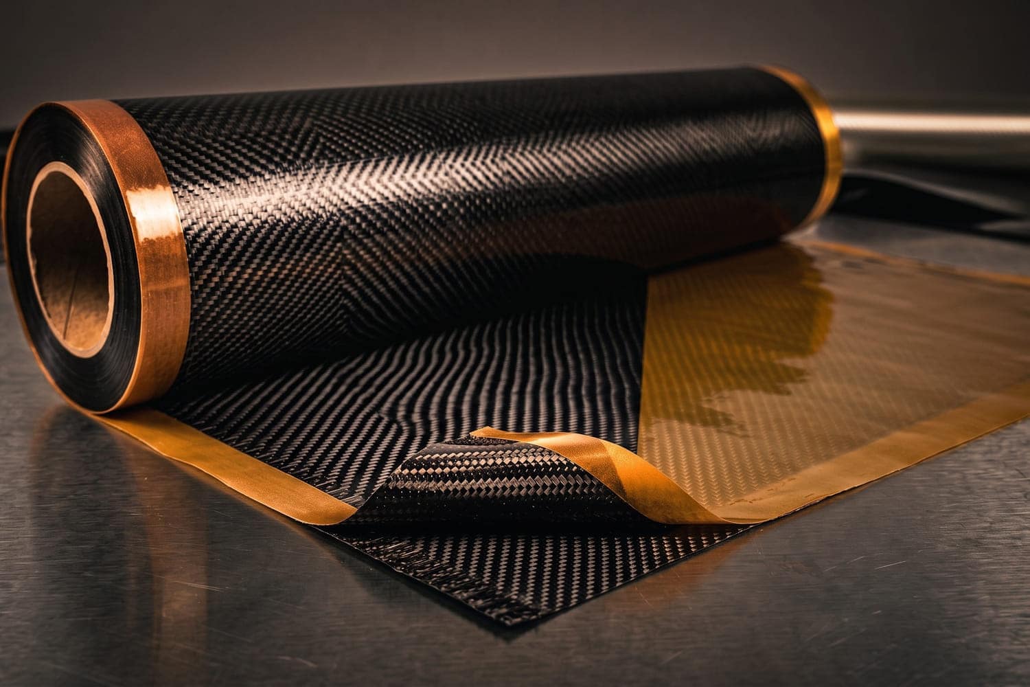 A roll of woven carbon fibre prepreg with the release film partly peeled back